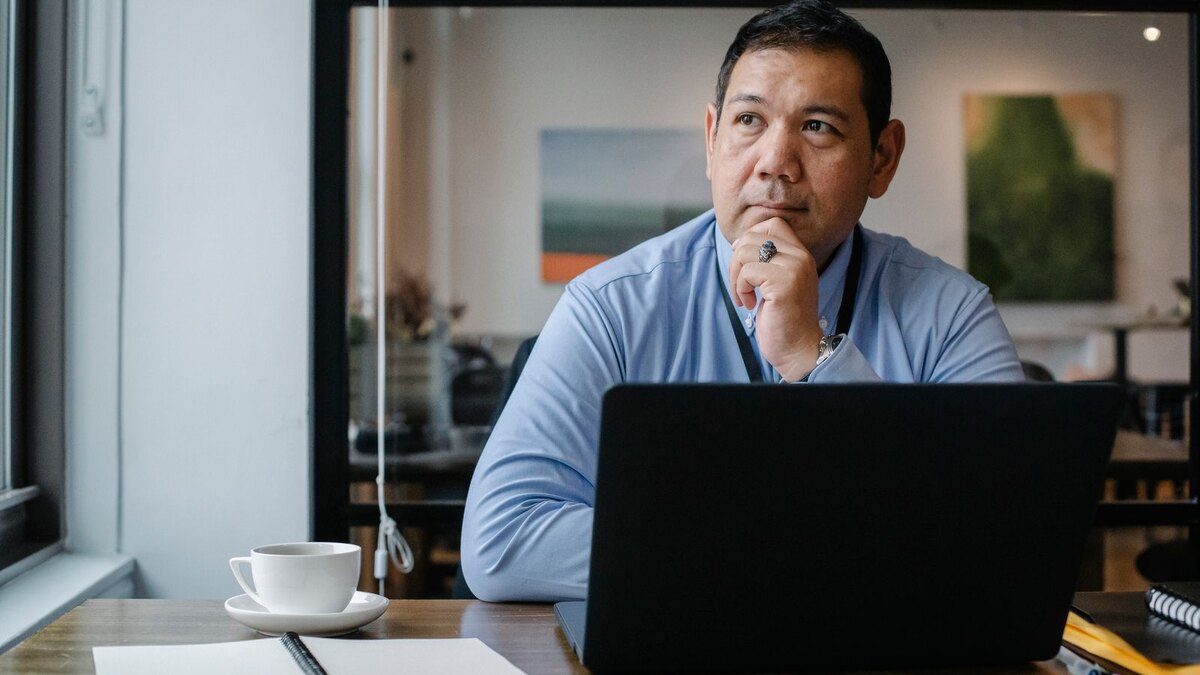 Small-business operator at a laptop considering the next inbox message